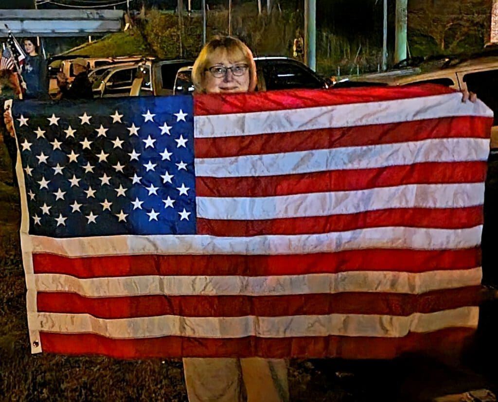 A woman proudly displays her flag. Photo by David Day